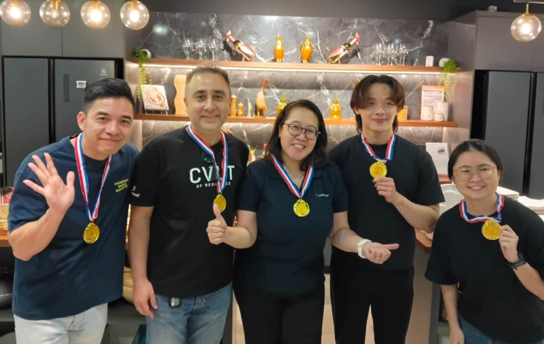 Kitchen Showdown team posing with gold medals after a culinary team building challenge
